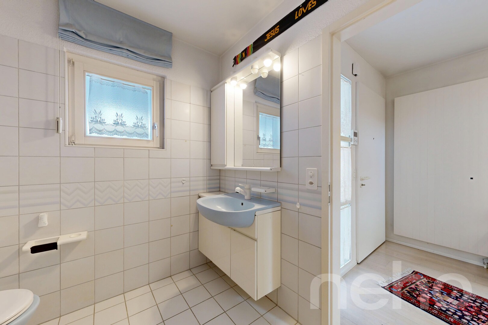 salle de bains avec lavabo (ou coiffeuse selon le contexte), mur en carrelage, tile wall, toilette, et miroir