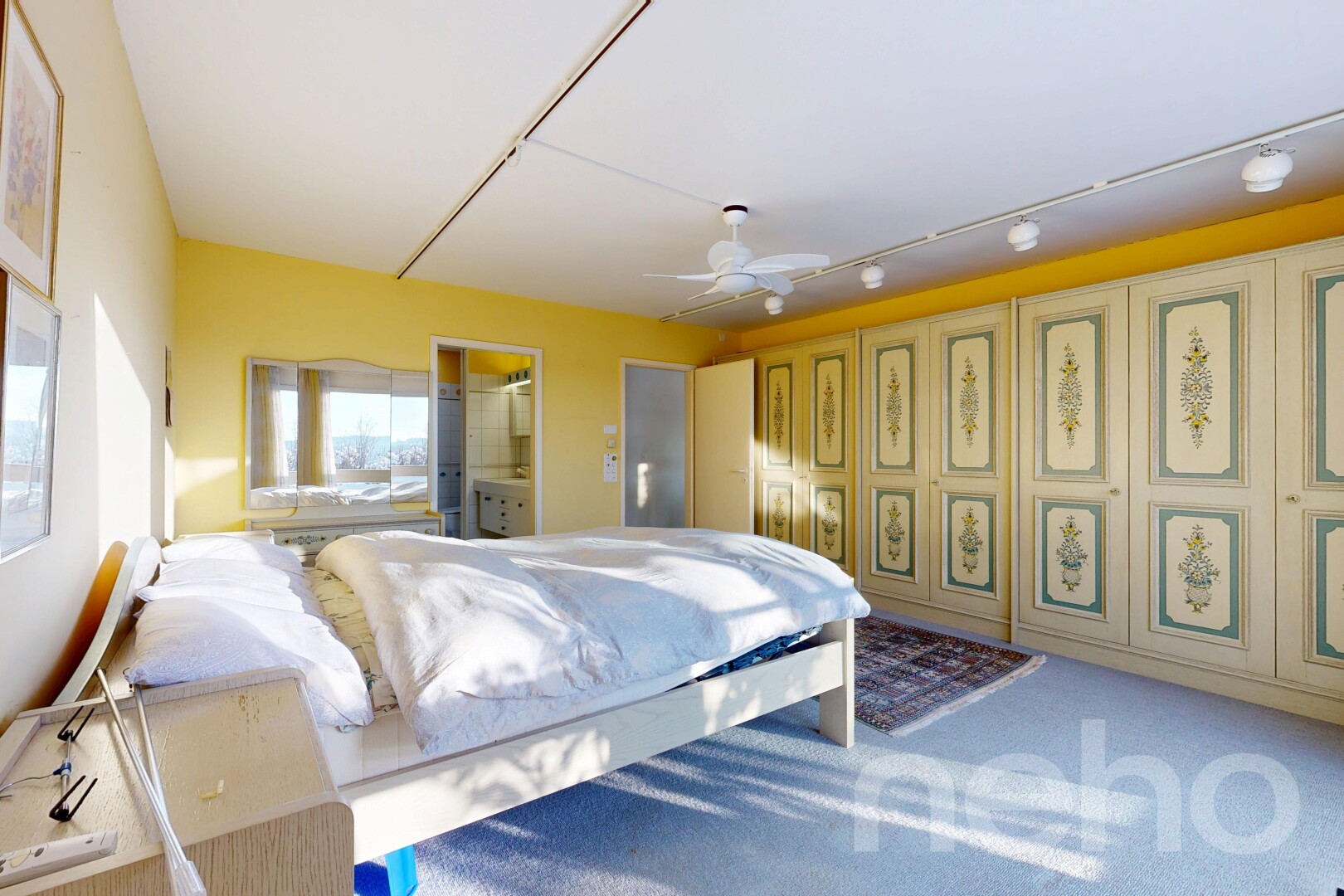 chambre avec inside property, salle de bain attenante, ventilateur de plafond, cloison sèche, et drywall