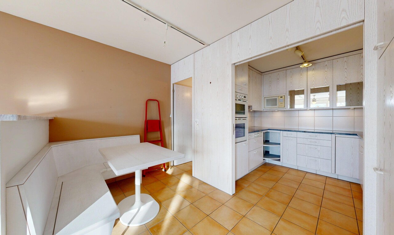 cuisine avec inside property, sol en carrelage, tile floor, micro-ondes, et armoires blanches