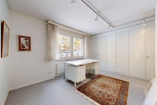 room / bedroom with rail lighting, radiator heating unit, light colored carpet, and an office area
