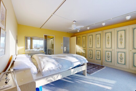room featuring connected bathroom, ceiling fan, and carpet