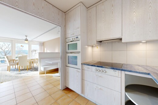 kitchen with white double oven, light tile patterned flooring, range hood, and dark countertops