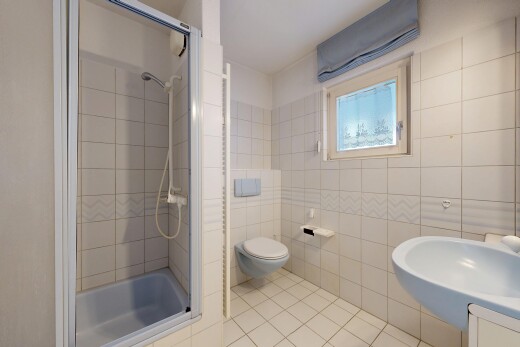 full bath with light tile patterned floors, tile walls, and vanity