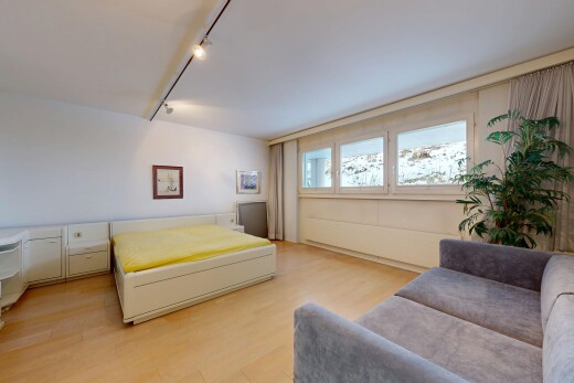 room / bedroom with rail lighting and light wood finished floors