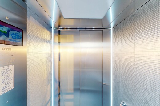 bathroom featuring a shower stall and elevator