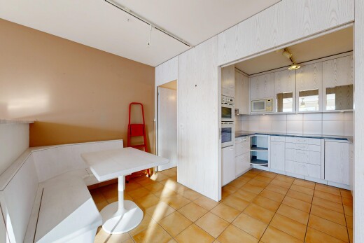 kitchen with light tile patterned floors, white appliances, white cabinetry, and light countertops
