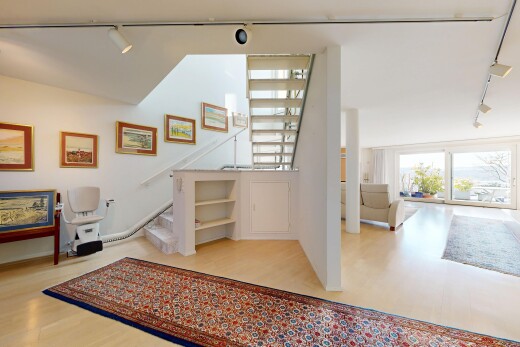 living area with rail lighting and light wood-style flooring