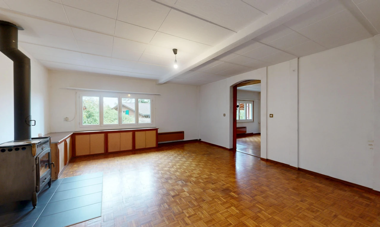 leerer raum mit holzofen, gewölbte gehwege, gipskartonwand, drywall, und parquet floor