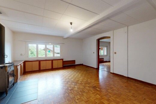 leerer raum mit holzofen, gewölbte gehwege, gipskartonwand, drywall, und parquet floor