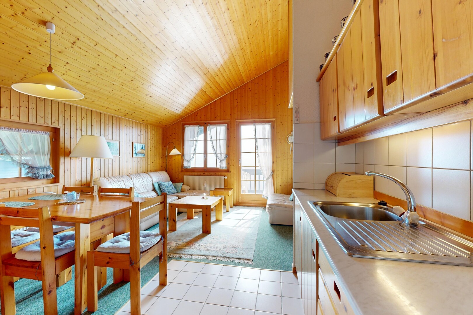 cuisine avec plans de travail, plafond voûté, vaulted ceiling, sol en carrelage, et tile floor