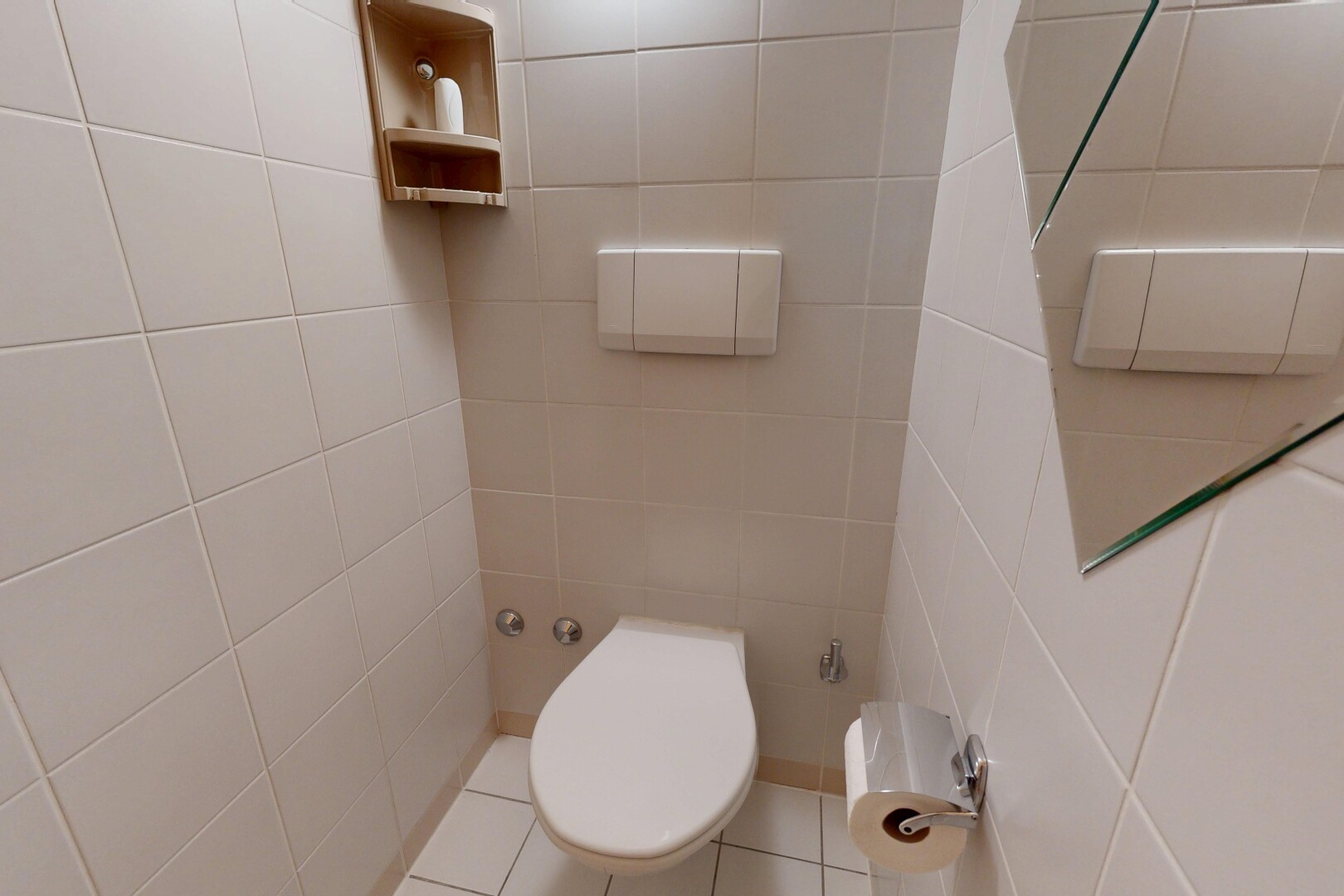 salle de bains avec inside property, tile wall, mur en carrelage, toilette, et tile floor