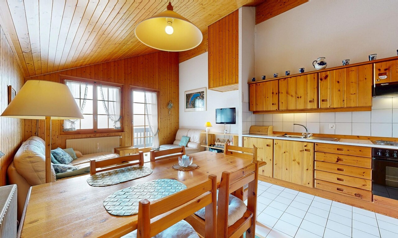 cuisine avec plans de travail, armoires marron moyen, vaulted ceiling, plafond voûté, et backsplash