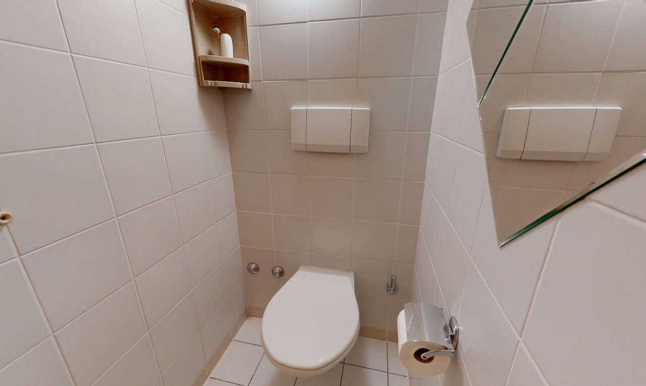 salle de bains avec inside property, tile wall, mur en carrelage, toilette, et tile floor