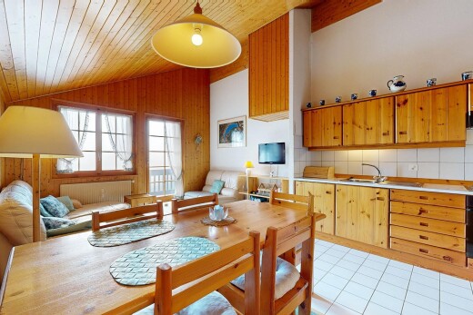 cuisine avec plans de travail, armoires marron moyen, vaulted ceiling, plafond voûté, et backsplash