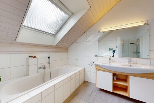 salle de bains avec salle de bain complète, puits de lumière, bain, double vasque, et plafond voûté