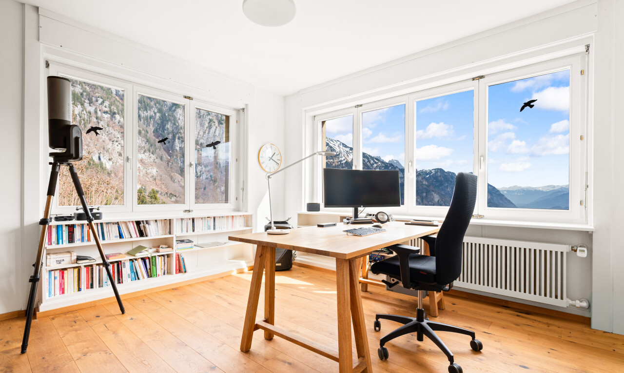 bureau avec espace bureau, télévision, radiateur, sol en finition bois, et wood finish floor