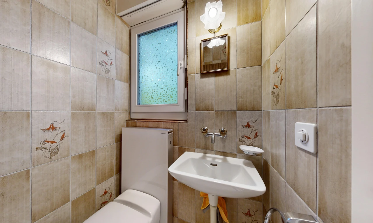 half bath with tile walls and toilet
