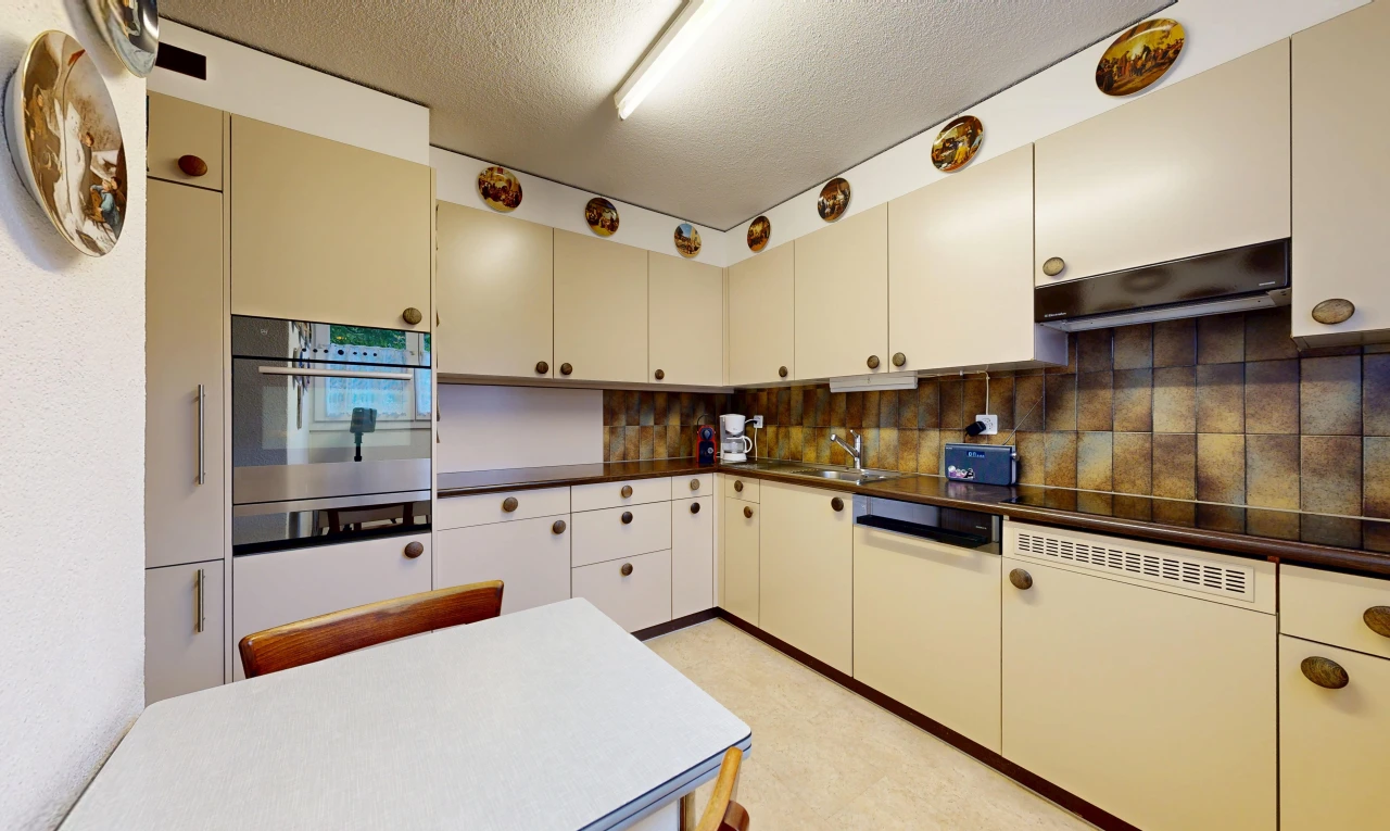 kitchen featuring dark countertops, oven, a textured ceiling, cream cabinets, and tasteful backsplash