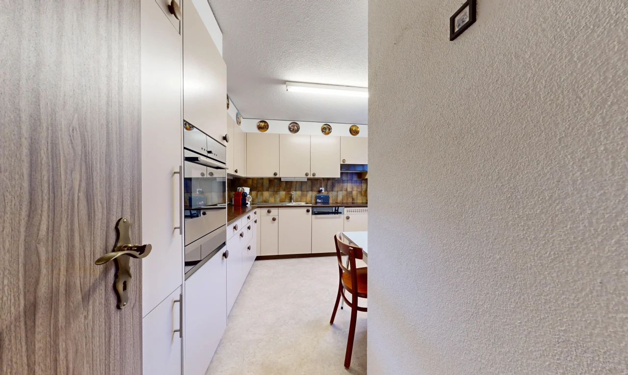kitchen with dark countertops, a textured wall, stainless steel oven, and decorative backsplash