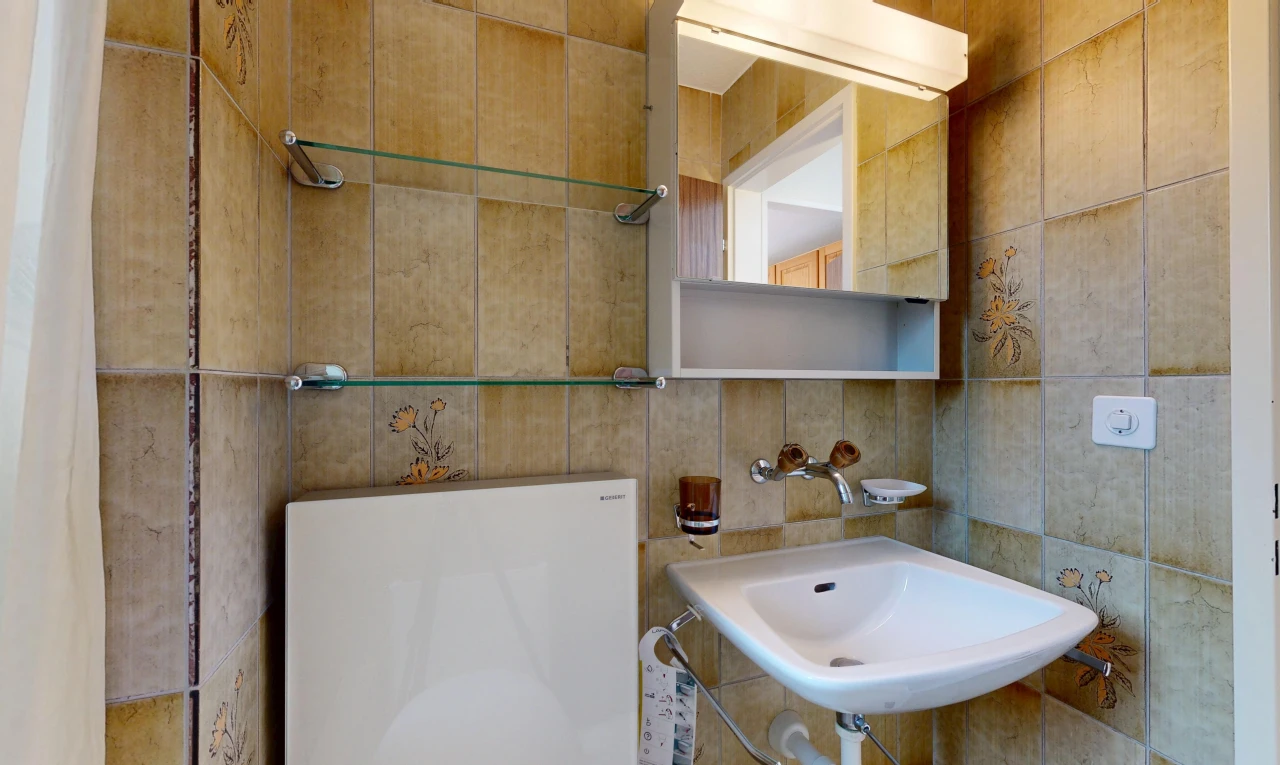 half bath featuring tile walls and a sink