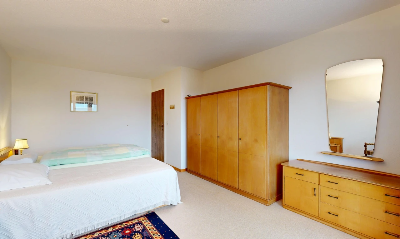 room / bedroom with light colored carpet and arched walkways