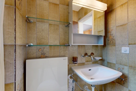 half bath featuring tile walls and a sink