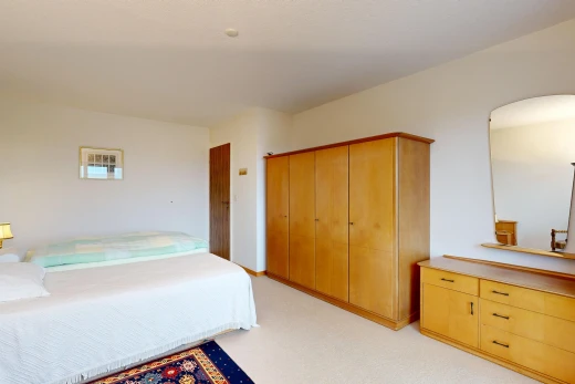 room / bedroom with light colored carpet and arched walkways