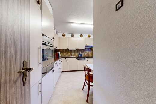 küche mit arbeitsplatten, dark countertops, light floor, strukturierte wand, und textured wall