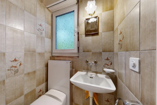 half bath with tile walls and toilet
