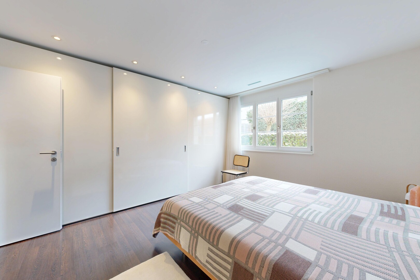 chambre avec inside property, lumière naturelle, natural light, sol en finition bois, et wood finish floor