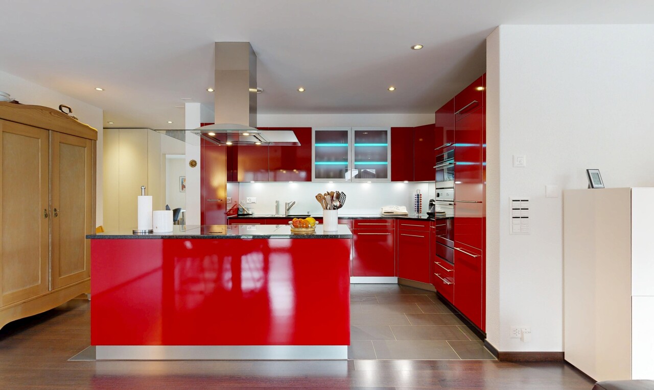 cuisine avec armoires rouges, armoires à panneau plat, hotte, inside property, et armoires avec insert en verre