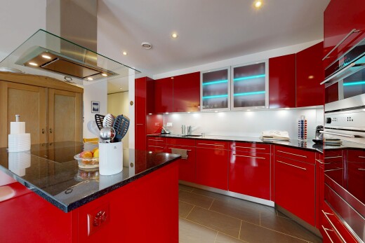 küche mit rote schränke, dunstabzugshaube, schränke mit flachen paneelen, doppel backofen, und tile floor