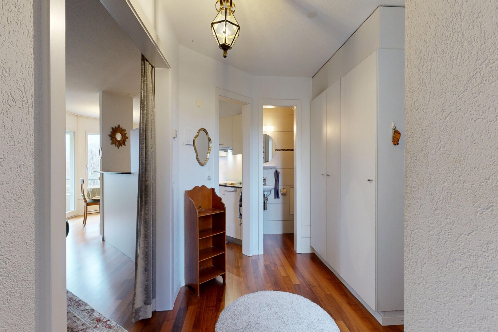 hall featuring wood finished floors and a textured wall