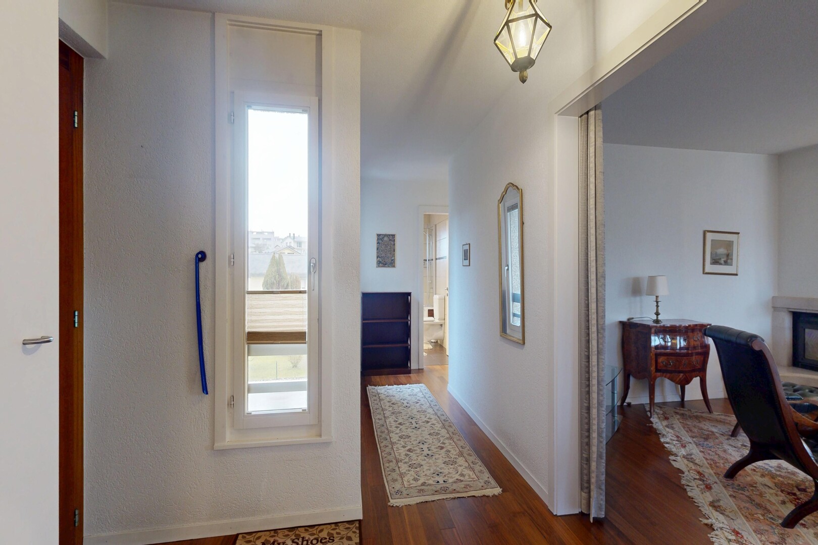 hall featuring dark wood-style flooring and baseboards