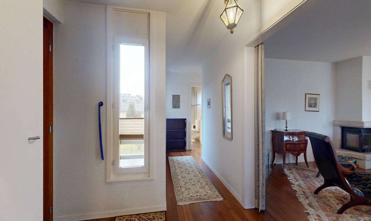 hall featuring dark wood-style flooring and baseboards