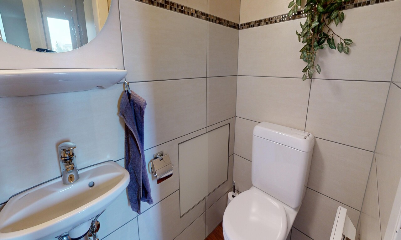 half bathroom with toilet and tile walls