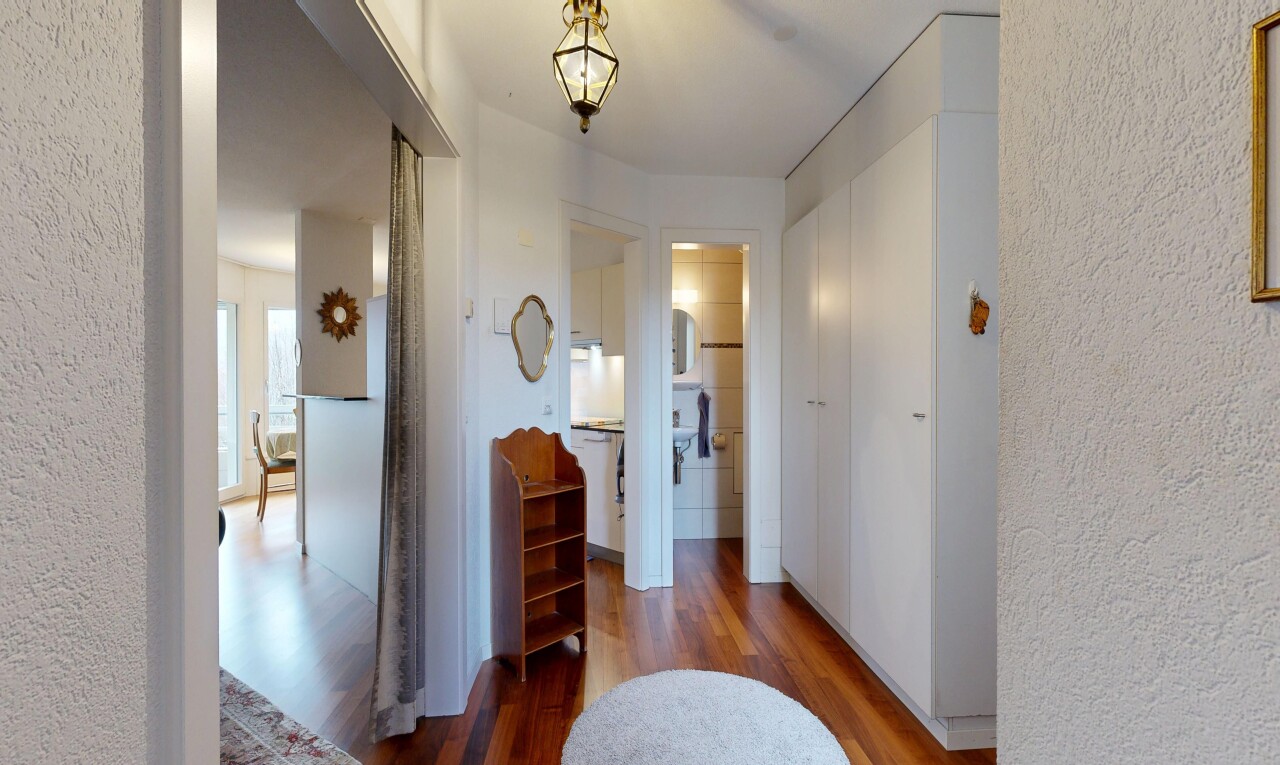 hall featuring wood finished floors and a textured wall
