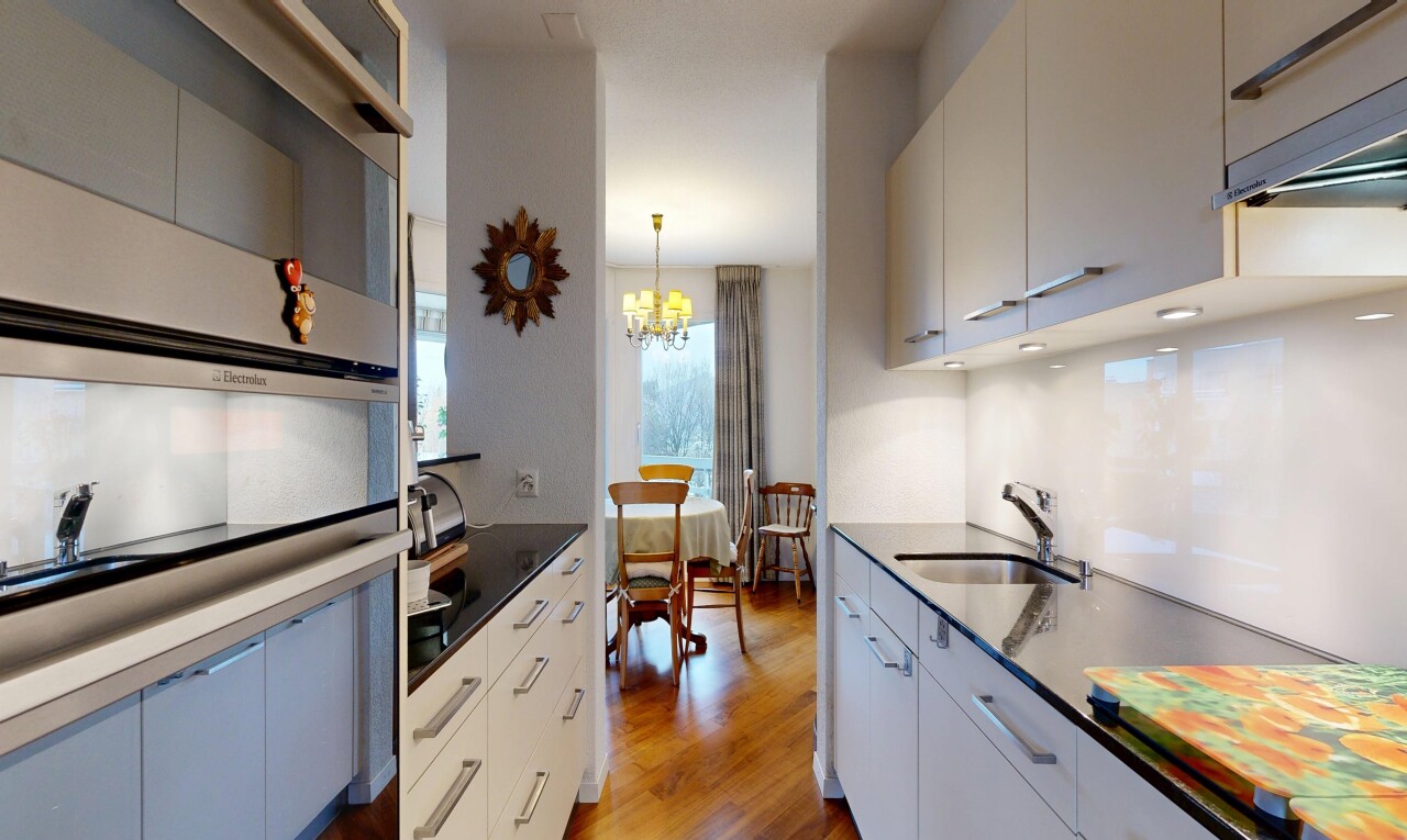 kitchen featuring light wood-style floors, a chandelier, dark stone counters, and modern cabinets