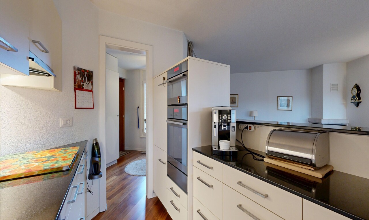 kitchen featuring white cabinetry, dark wood finished floors, stainless steel double oven, dark stone countertops, and exhaust hood