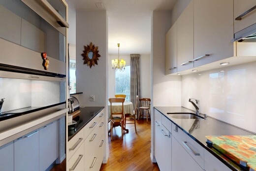 kitchen featuring light wood-style floors, a chandelier, dark stone counters, and modern cabinets
