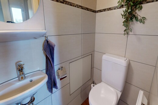 salle de bains avec miroir, toilette, évier, inside property, et tile wall