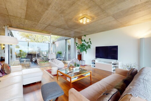 wohnzimmer mit natürliches licht, bodendeckenfenster, gipskartonwand, holzfußboden, und fernseher