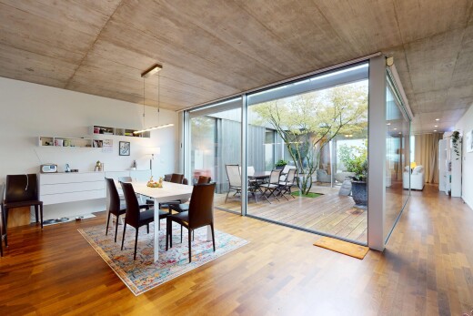 esszimmer mit natürliches licht, holzfußboden, betondecke, und bodendeckenfenster