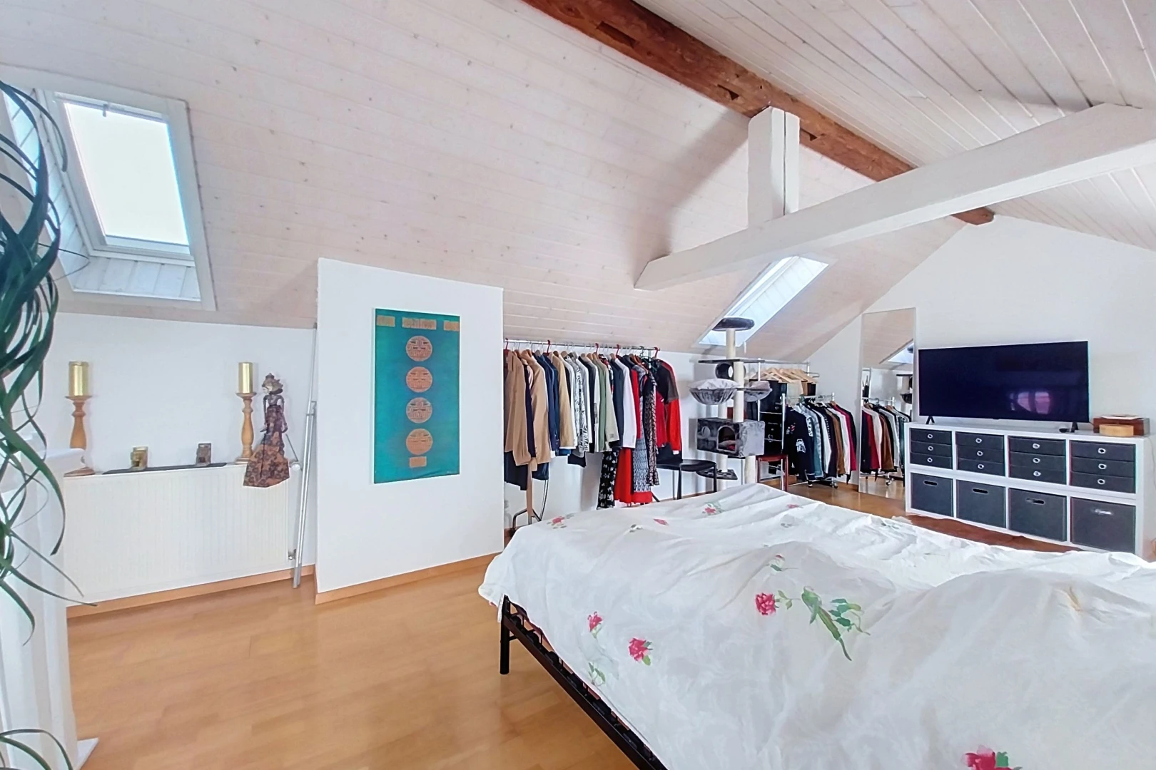 zimmer / schlafzimmer mit dachschräge, vaulted ceiling, high end ceiling, fernseher, und holzfußboden