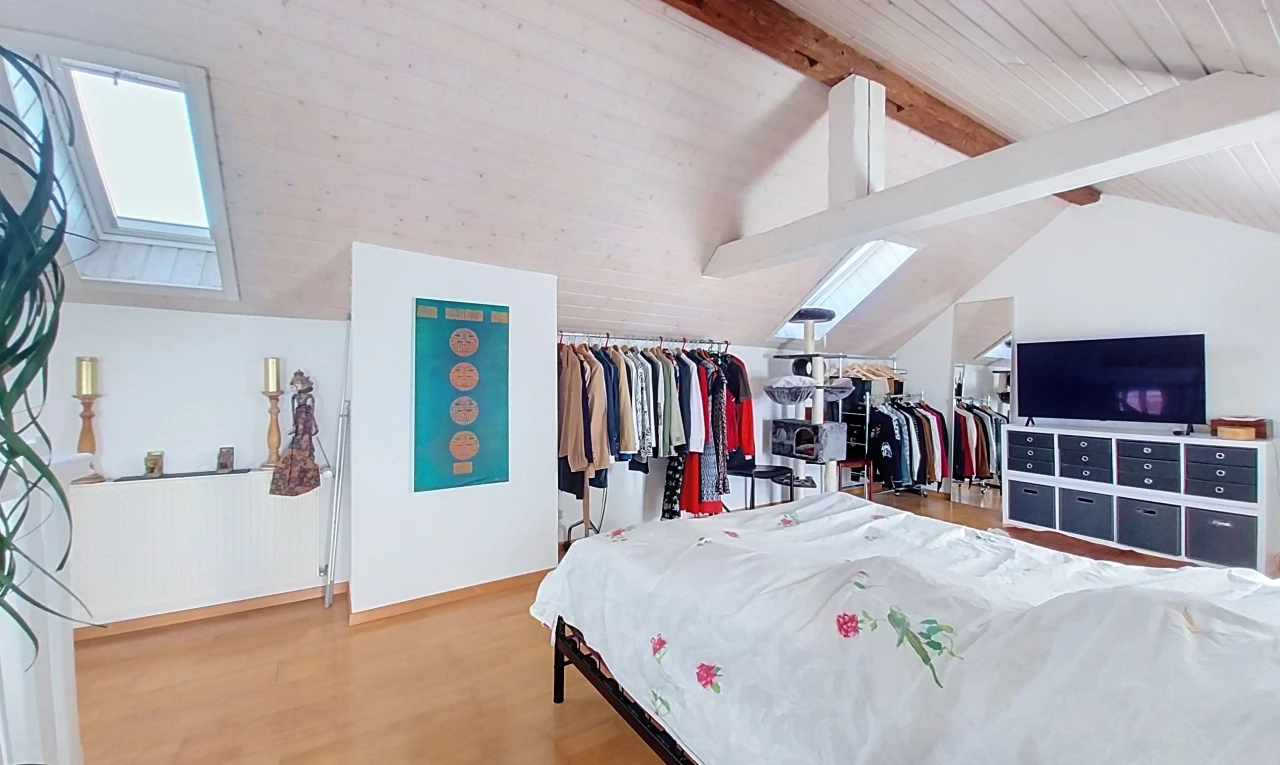 zimmer / schlafzimmer mit dachschräge, vaulted ceiling, high end ceiling, fernseher, und holzfußboden