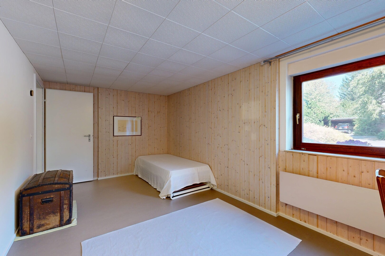 zimmer / schlafzimmer mit dated wood wall, holzwand, wood wall, inside property, und natürliches licht