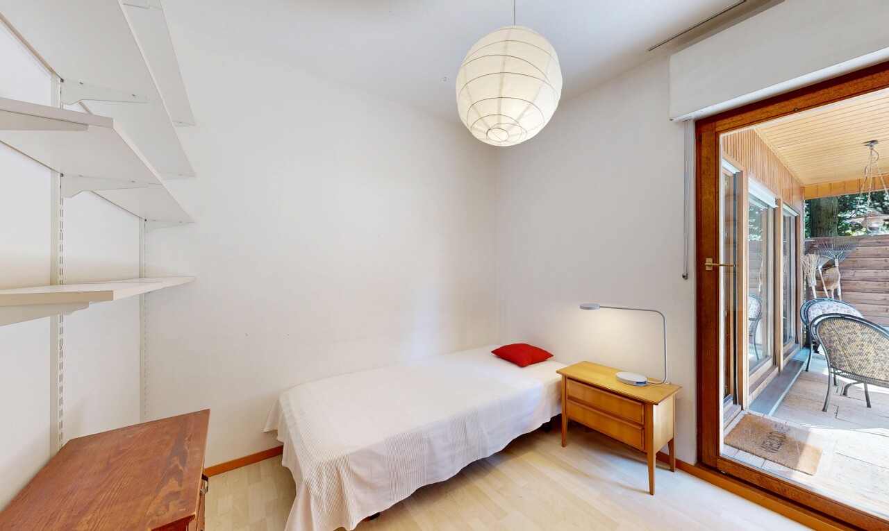 zimmer / schlafzimmer mit holzfußboden, wood finish floor, gipskartonwand, drywall, und pendelleuchte