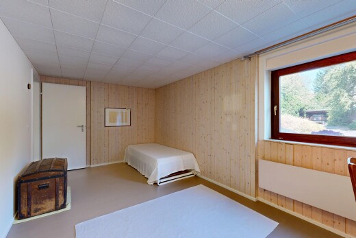 zimmer / schlafzimmer mit dated wood wall, holzwand, wood wall, inside property, und natürliches licht
