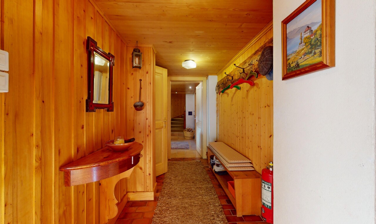 couloir avec inside property, plafond en bois, wood ceiling, escaliers, et mur en bois