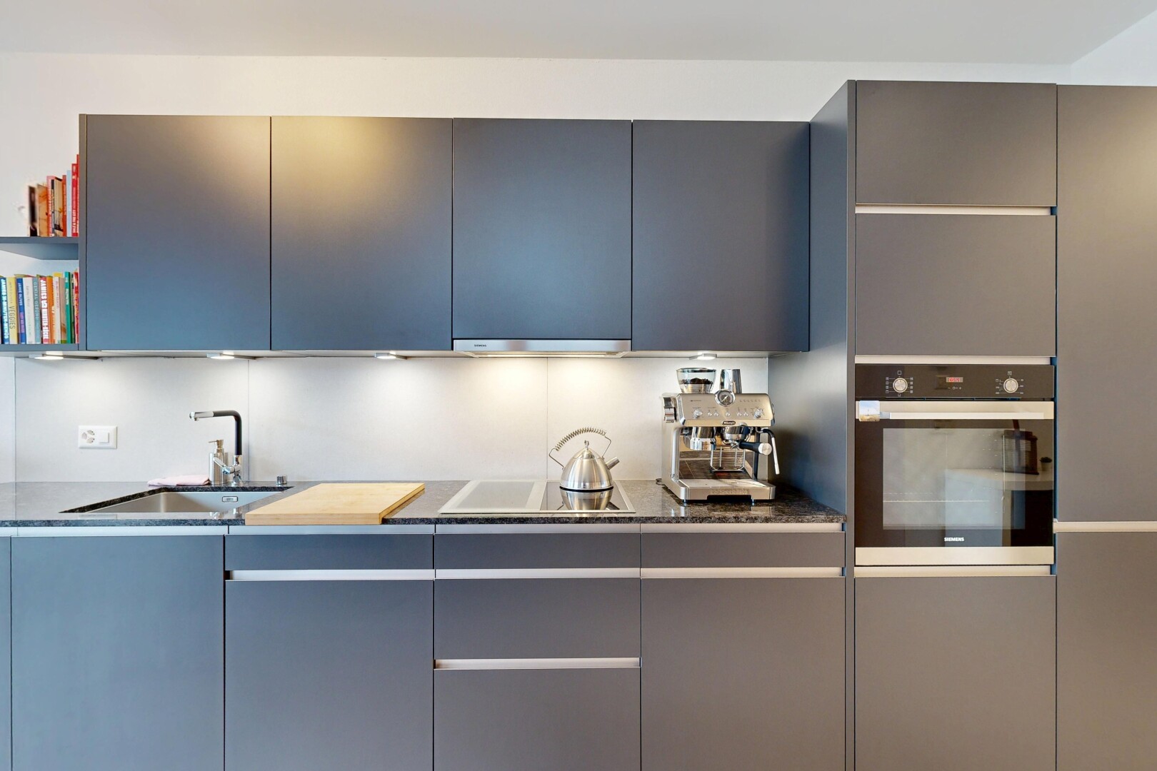 cuisine avec flat panel cabinets, armoires à panneau plat, four, évier, et dark countertops
